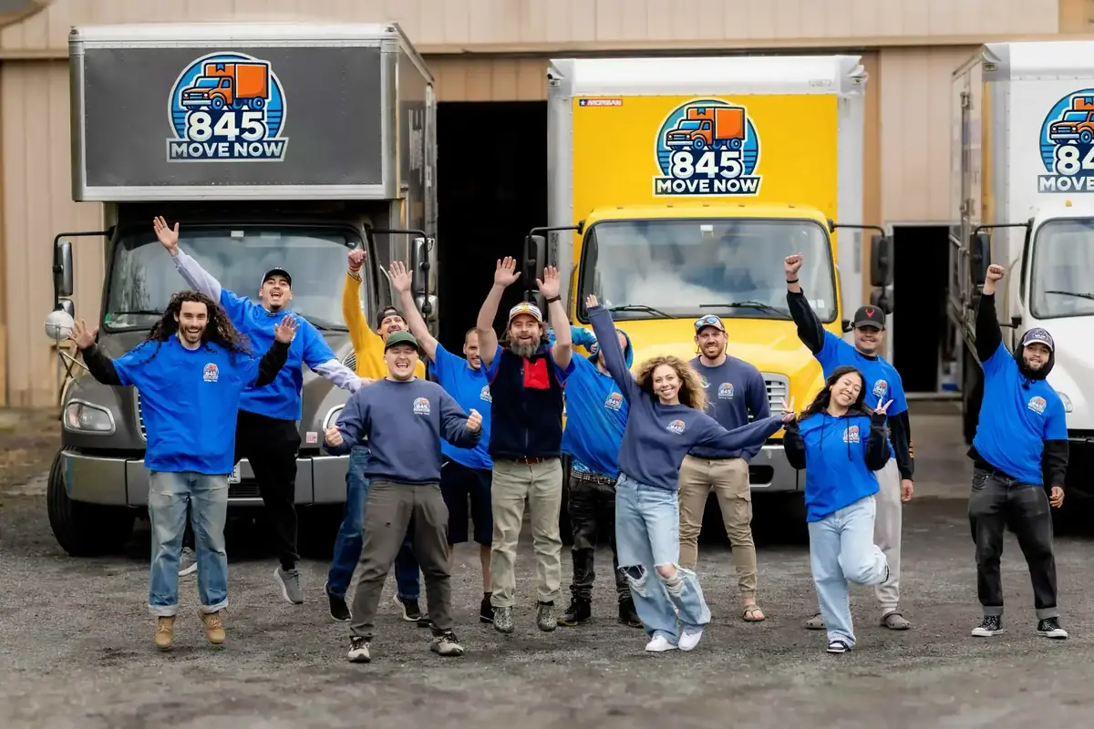 845 Move Now movers waving beside a yellow moving truck