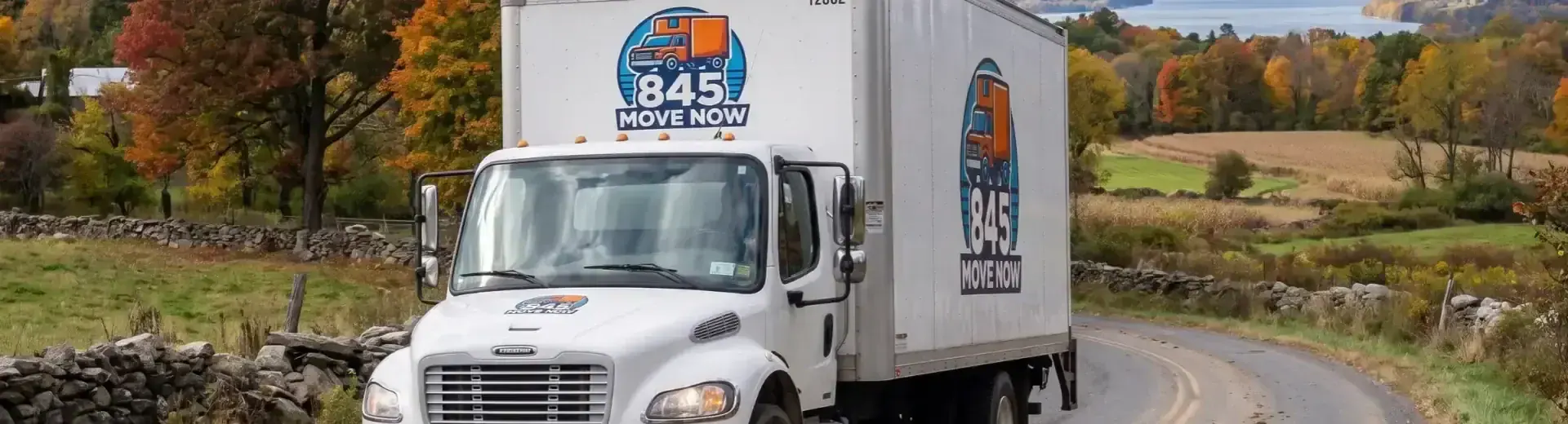 Plattekill, NY moving company truck from 845 Move Now on a country road lined with stone walls